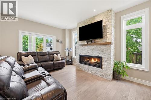 Living area featuring a stone-clad fireplace with a wood mantel, recessed lighting, and light wood-finish flooring - 1 Lindsay Way, Grimsby, ON - Indoor Photo Showing Living Room With Fireplace