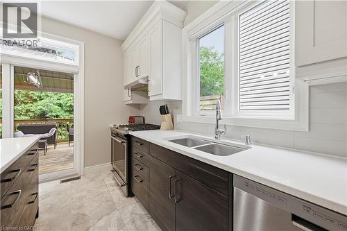 Contemporary kitchen featuring two-tone cabinetry, stainless steel appliances, a double basin sink, and white countertops - 1 Lindsay Way, Grimsby, ON - Indoor Photo Showing Kitchen With Double Sink