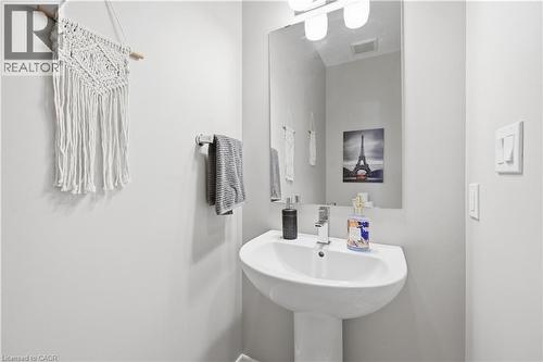 Pedestal sink with chrome faucet, large vanity mirror, and overhead light fixture - 1 Lindsay Way, Grimsby, ON - Indoor Photo Showing Bathroom