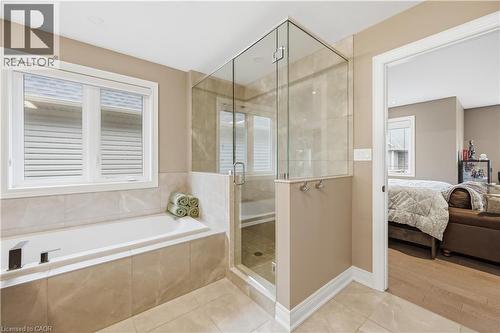 Bathroom featuring a built-in tub with tile surround, a glass-enclosed shower, and neutral wall paint - 1 Lindsay Way, Grimsby, ON - Indoor Photo Showing Bathroom