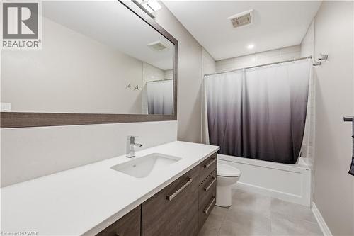 Bathroom featuring a contemporary vanity with a white countertop, undermount sink, and chrome faucet - 1 Lindsay Way, Grimsby, ON - Indoor Photo Showing Bathroom