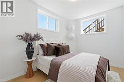 Bright room featuring light wood-finish flooring and white painted walls - 