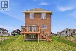 Brick exterior with a multi-level wooden deck featuring stairs to the lawn - 