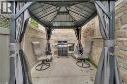 Outdoor gazebo featuring a metal roof and gray privacy curtains - 