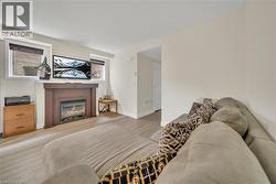 Living area featuring a gas fireplace with a wood mantel, light wood-finish flooring, and painted walls - 