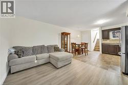 Open-concept living space featuring wood-finish flooring transitioning to large format tile - 