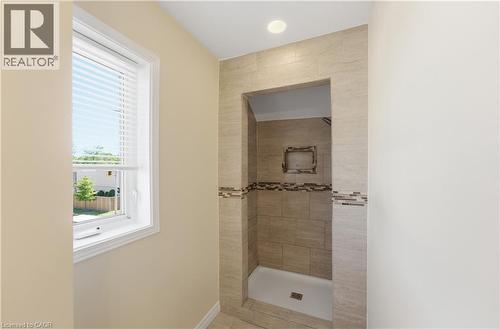 Walk-in shower with neutral-toned rectangular tile, mosaic accent band, and recessed niche - 309 Cope Street, Hamilton, ON - Indoor Photo Showing Bathroom