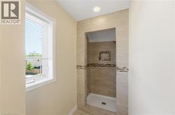 Walk-in shower with neutral-toned rectangular tile, mosaic accent band, and recessed niche - 