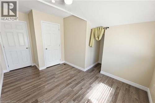 Room featuring wood-finish flooring, neutral wall tones, and white trim - 309 Cope Street, Hamilton, ON - Indoor Photo Showing Other Room