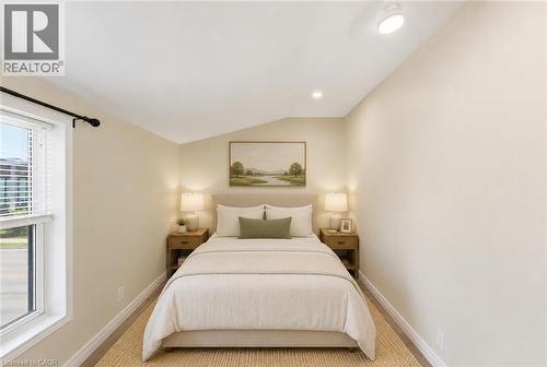 Virtually Staged - Bedroom featuring wood-finish flooring, two paneled doors, a window with horizontal blinds, and a ceiling with recessed and track lighting - 309 Cope Street, Hamilton, ON - Indoor Photo Showing Bedroom