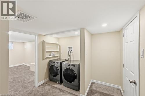 Dedicated laundry area with a built-in shelving unit, overhead lighting, and a white paneled door - 309 Cope Street, Hamilton, ON - Indoor Photo Showing Laundry Room