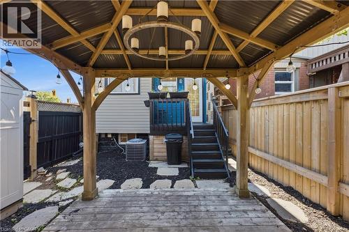 Wood gazebo featuring a corrugated metal roof and an overhead chandelier - 309 Cope Street, Hamilton, ON - Outdoor With Exterior