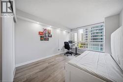 Bright interior space featuring wood-finish flooring, recessed lighting, and expansive window with urban surroundings - 