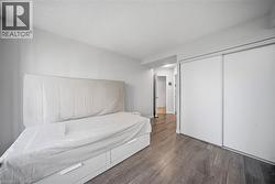 Bright room featuring wood-finish flooring, white walls, and a white ceiling - 