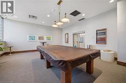 Recreation room featuring a pool table with a brown cover, recessed lighting, and a multi-light fixture - 