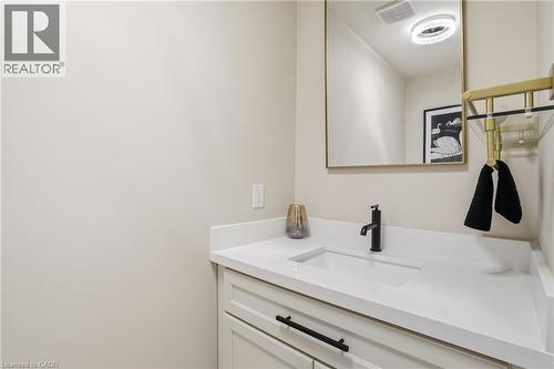 White shaker vanity with matte black hardware, integrated rectangular sink, white countertop, and contemporary matte black faucet - 56 Mccaffery Crescent, St. Catharines, ON 