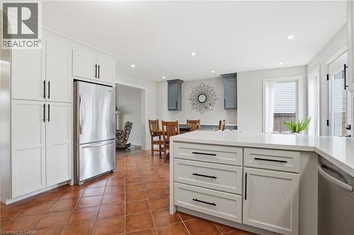 Kitchen featuring white cabinetry, stainless steel refrigerator, recessed lighting, tile flooring, and a central island with a light-toned countertop - 56 Mccaffery Crescent, St. Catharines, ON 
