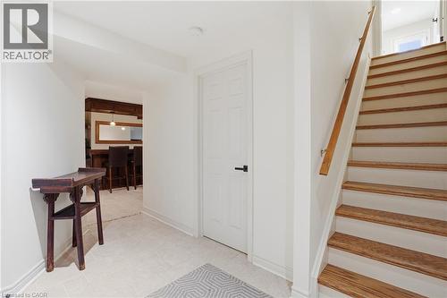 Staircase with wood-finish treads and white risers, featuring a natural wood-finish handrail - 56 Mccaffery Crescent, St. Catharines, ON 