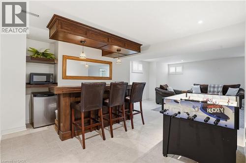 Custom wood bar with built-in cabinetry and pendant lighting - 56 Mccaffery Crescent, St. Catharines, ON 