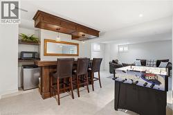 Custom wood bar with built-in cabinetry and pendant lighting - 