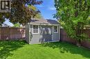 Backyard featuring a gray storage shed with white trim and a shingled roof, set against a wood fence - 56 Mccaffery Crescent, St. Catharines, ON 