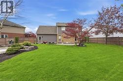 Expansive green lawn with established landscaping and a paved patio area - 