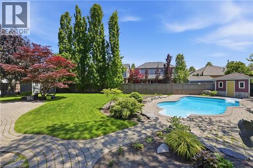Expansive backyard featuring a freeform swimming pool with integrated steps, surrounded by paver patio hardscaping - 56 Mccaffery Crescent, St. Catharines, ON 