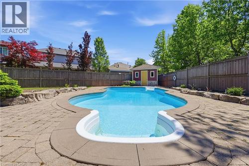 In-ground swimming pool featuring integrated steps and a surrounding paved patio - 56 Mccaffery Crescent, St. Catharines, ON 