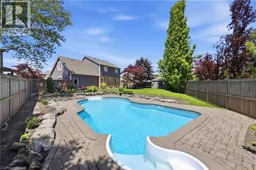 Inviting backyard with an in-ground pool featuring a white slide - 56 Mccaffery Crescent, St. Catharines, ON 