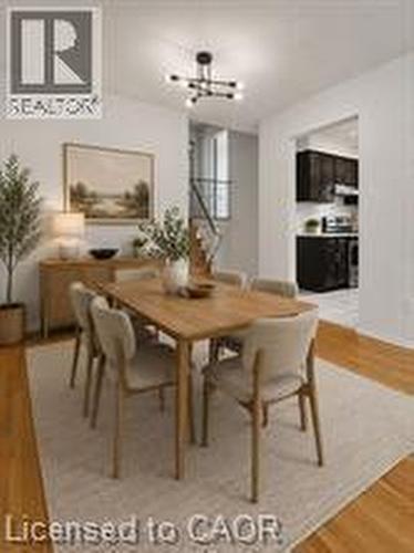 Bright dining area featuring wood-finish flooring, a contemporary chandelier, and an opening to the kitchen - 396 Pinemeadow Avenue, Mississauga, ON 