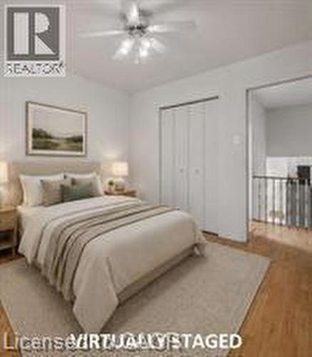 Bedroom featuring wood-finish flooring, a ceiling fan with integrated lighting, and white bi-fold closet doors - 396 Pinemeadow Avenue, Mississauga, ON 