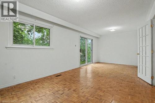 Room featuring parquet wood flooring, white walls, and a sliding glass door - 396 Pinemeadow Avenue, Mississauga, ON 