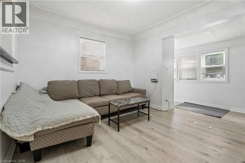 Open-concept living area featuring light wood-finish flooring and white walls - 43 Whitfield Avenue, Hamilton, ON 