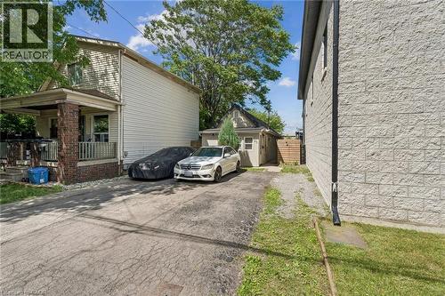 Two-story residence with a covered front porch featuring brick pillars and white railing - 43 Whitfield Avenue, Hamilton, ON 