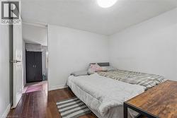 Room featuring wood-finish flooring, white walls, and a flush-mount ceiling light - 