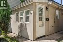 Stucco exterior featuring multiple windows and a white paneled entry door - 43 Whitfield Avenue, Hamilton, ON 