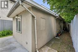 Stucco exterior with white trim windows and a wall-mounted light fixture - 