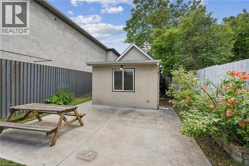 Private outdoor concrete patio space with a stucco-finished exterior wall and a single window - 43 Whitfield Avenue, Hamilton, ON 