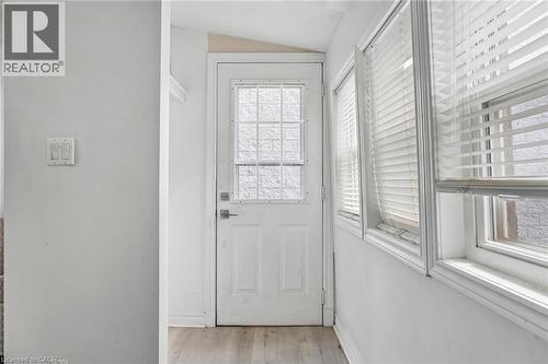 Entryway featuring a panel door with a decorative glass insert, flanked by multiple windows - 43 Whitfield Avenue, Hamilton, ON 