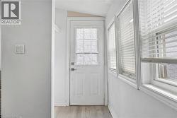 Entryway featuring a panel door with a decorative glass insert, flanked by multiple windows - 