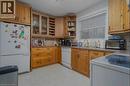Kitchen featuring wood cabinetry, integrated wine rack, glass-front display cabinets, light-toned countertops, and a full window - 98 Brubacher Street, Kitchener, ON 