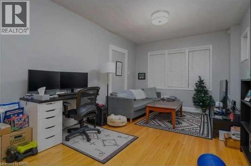 Open-concept room featuring wood-finish flooring, light gray wall paint, and white trim - 98 Brubacher Street, Kitchener, ON 