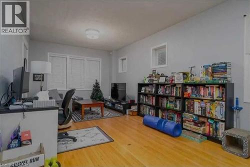 Living area featuring wood flooring, neutral wall tones, a multi-pane window with blinds, and recessed lighting - 98 Brubacher Street, Kitchener, ON 