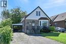Stone and siding exterior featuring a covered carport, bay window, front entryway with a wrought iron railing, and an arched storm door - 83 Aberfoyle Avenue, Hamilton, ON 