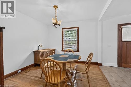 Hardwood flooring extending through the space, complemented by a window with natural wood trim - 83 Aberfoyle Avenue, Hamilton, ON 