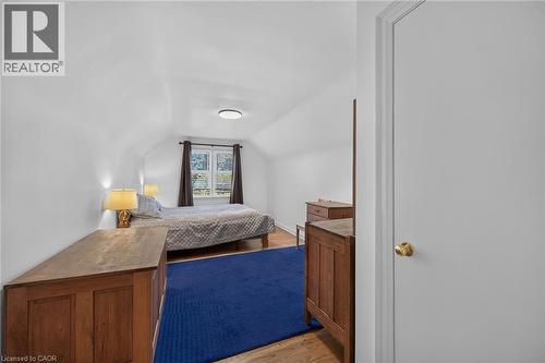 Room featuring sloped ceilings, a double window, wood-finish flooring, and a flush-mount ceiling light - 83 Aberfoyle Avenue, Hamilton, ON 