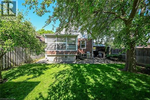 Expansive backyard featuring a lush lawn, mature shade trees, and a privacy fence - 83 Aberfoyle Avenue, Hamilton, ON 