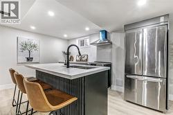 Kitchen island with an undermount double-basin sink, a matte black faucet, and a light-toned countertop - 