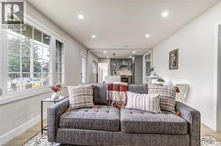 Bright living area featuring large pane windows, recessed lighting, and wood-finish flooring - 