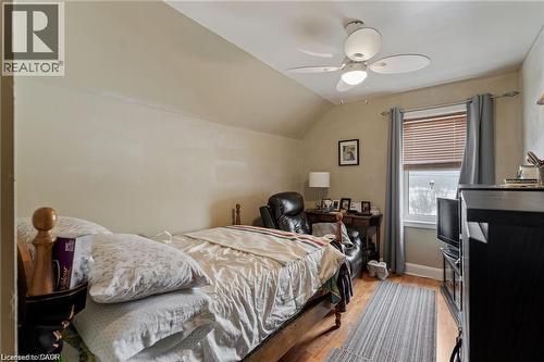 Room featuring wood-finish flooring, a window with blinds and drapes, and a ceiling fan with integrated lighting - 2 Mill Street E, York, ON 